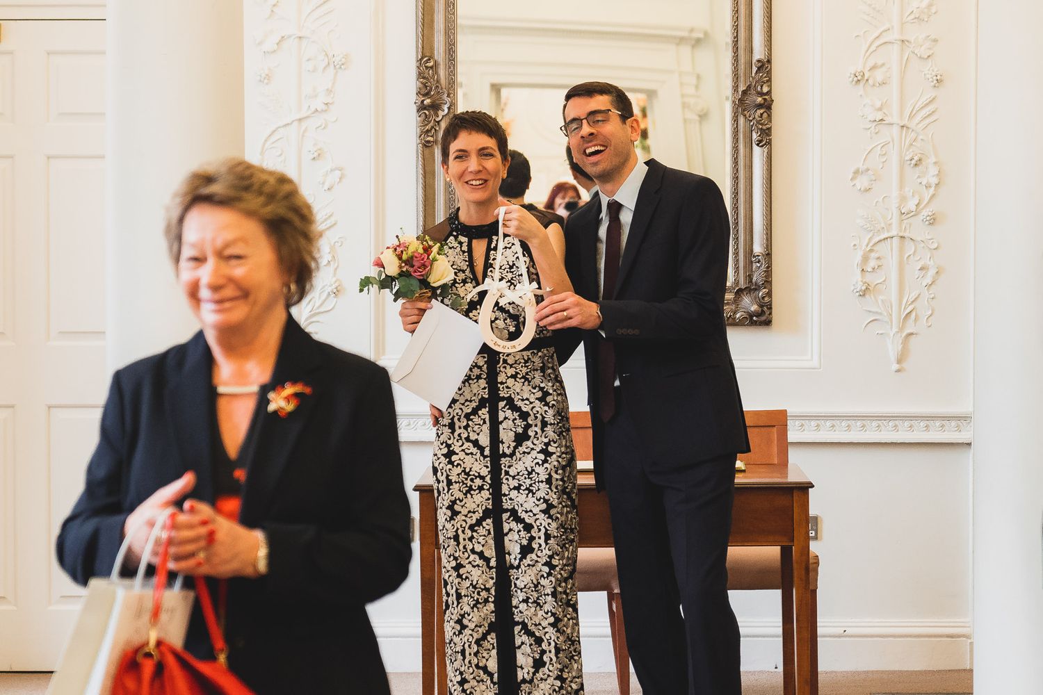Bride and groom laugh as a relative gives them a lucky horseshoe after their Salisbury ceremony.