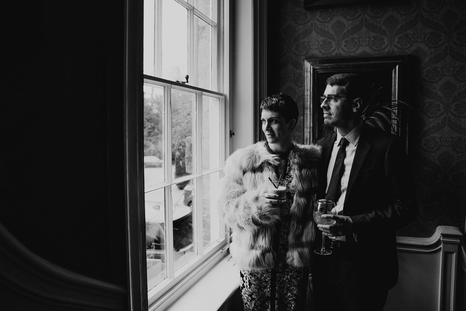 Black and white photo of bride and groom looking out of the window at 10 Castle Street, Dorset