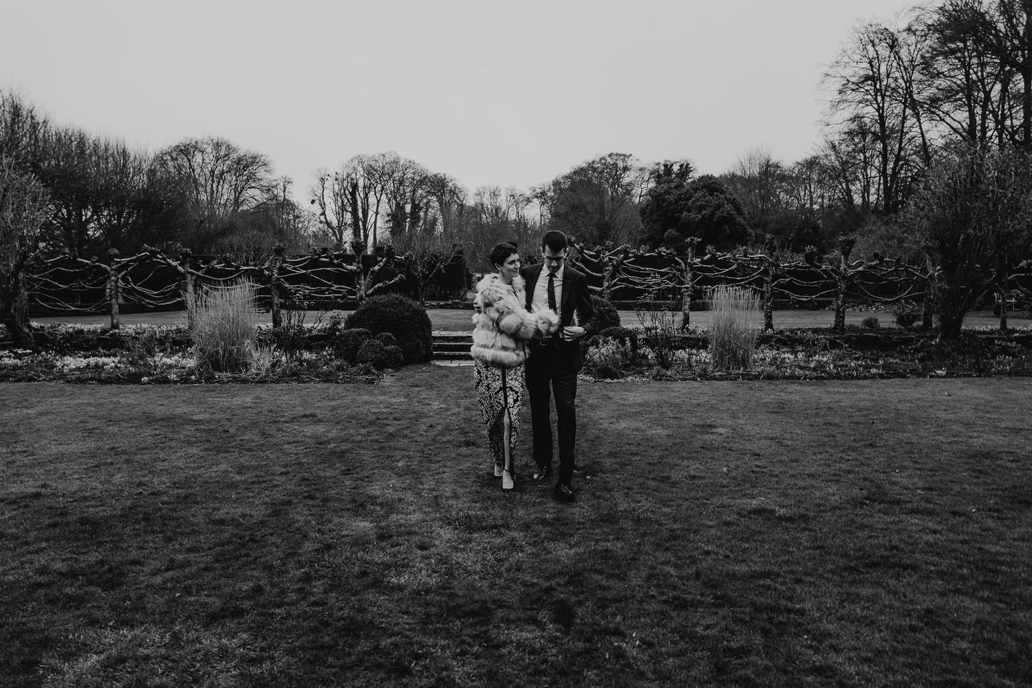 black and white photo of bride and groom walking across the lawns at 10 Castle Street, Dorset.