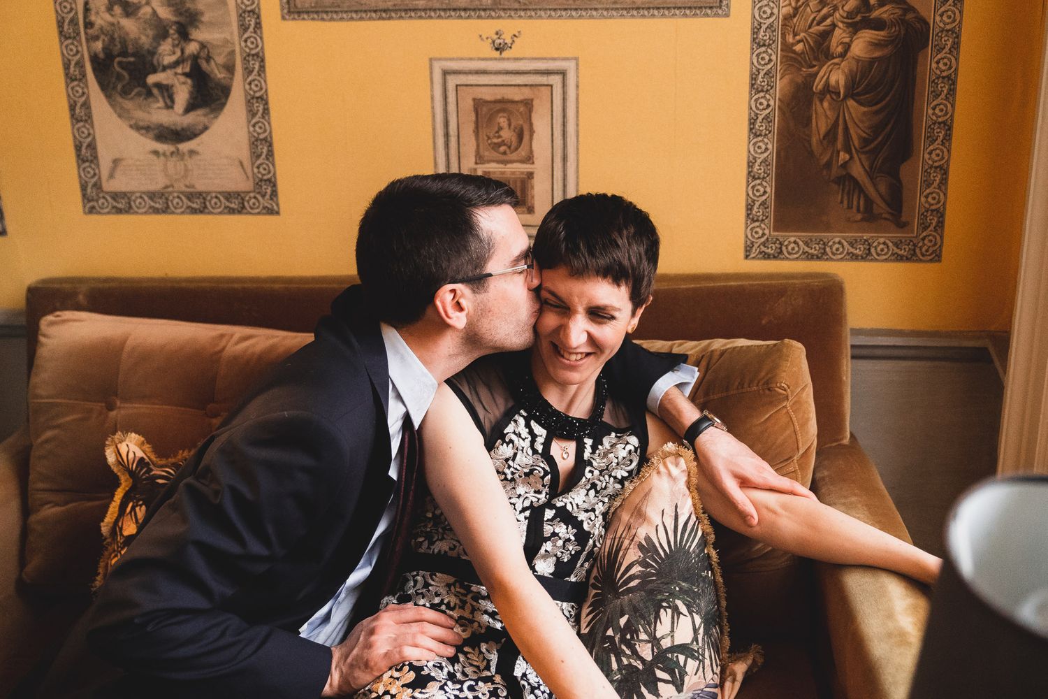 Bride and groom kiss and cuddle on a sofa at their Dorset wedding venue, 10 Castle Street.