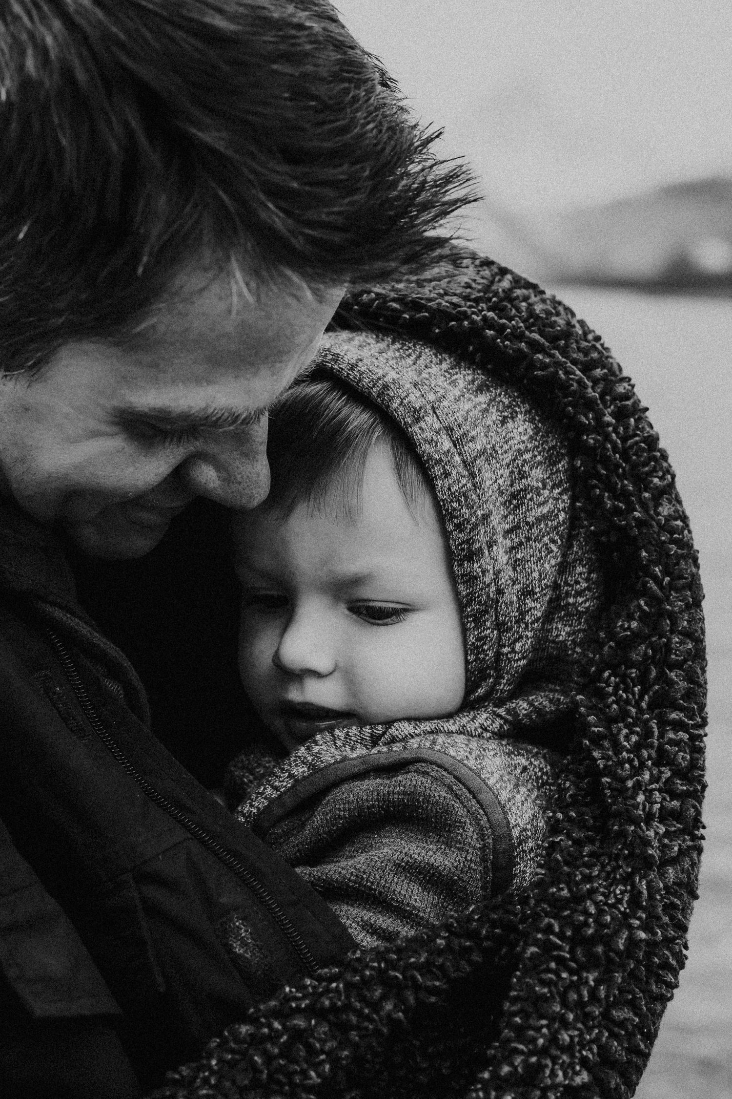 dad holds son in blanket to keep him warm