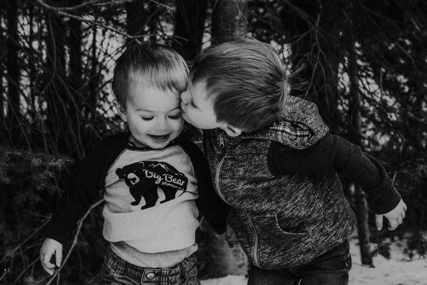 big brother kisses younger brother on the forehead
