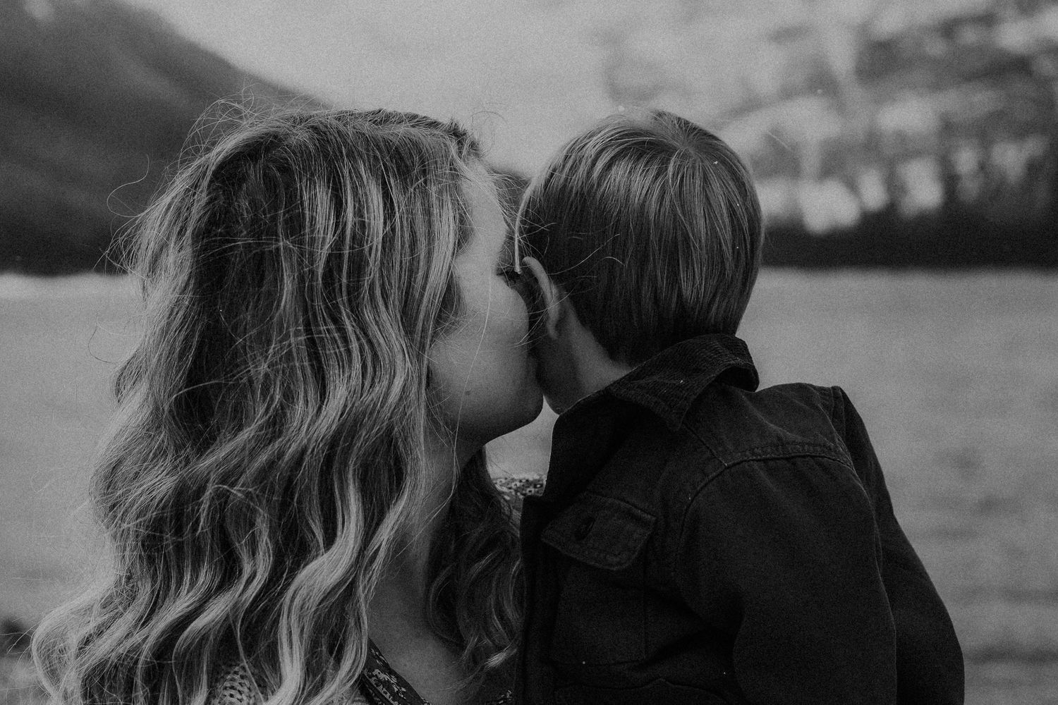 mother kisses baby boy on the cheek