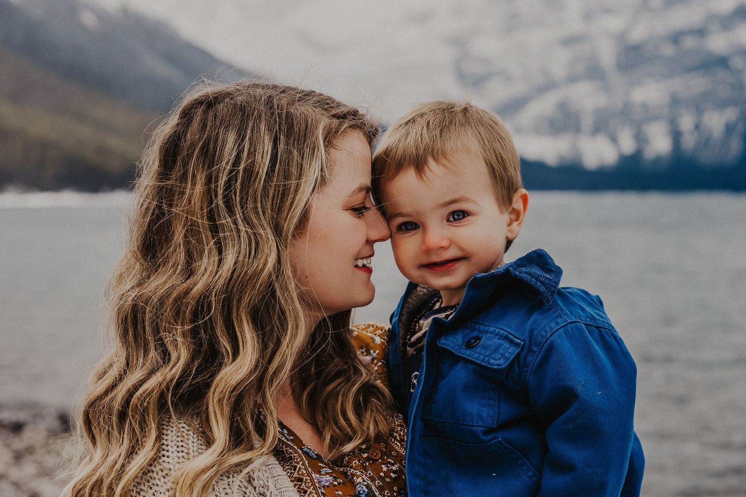 mother smiles while nuzzling baby boy's face