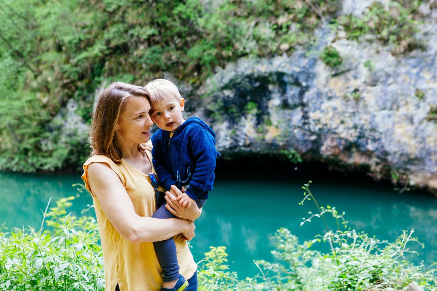 mum and son by turquoise lake in Garfagnana Tuscany by family portrait photographer Elizabeth Armitage