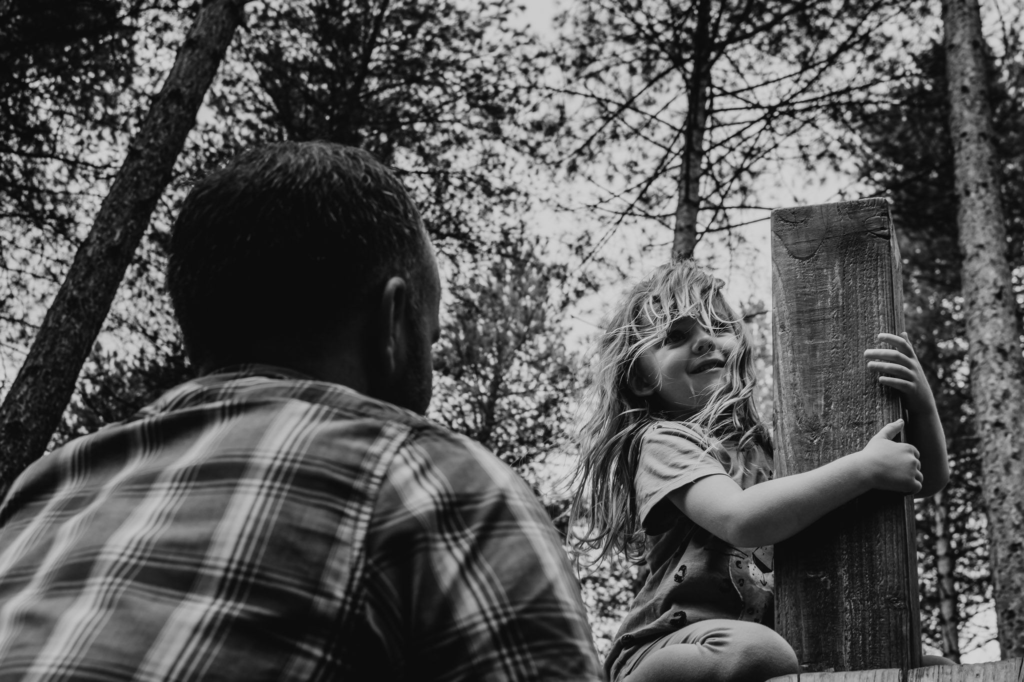 Black and white image of a five year old girl on a climbing frame on a family photoshoot in Southampton