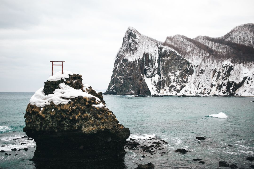 Torii gate on a sea stack in the sea of Japan, in Hokkaido winter
