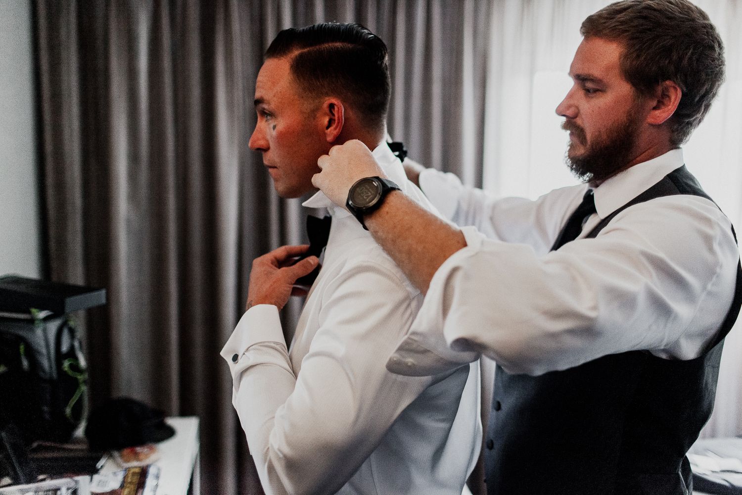 groom helping put on bow tie at hyatt regency