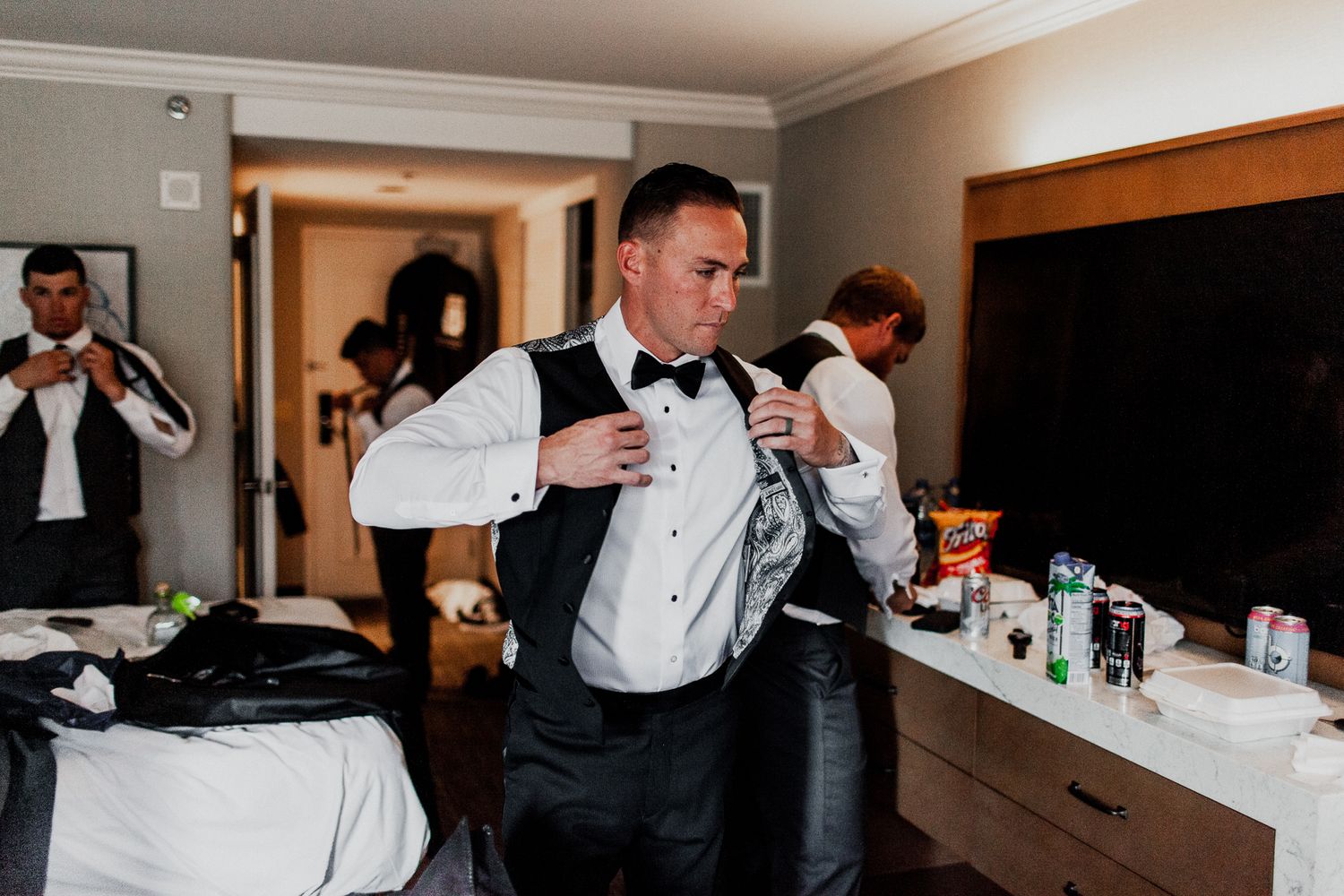 groom putting on vest preparation for wedding