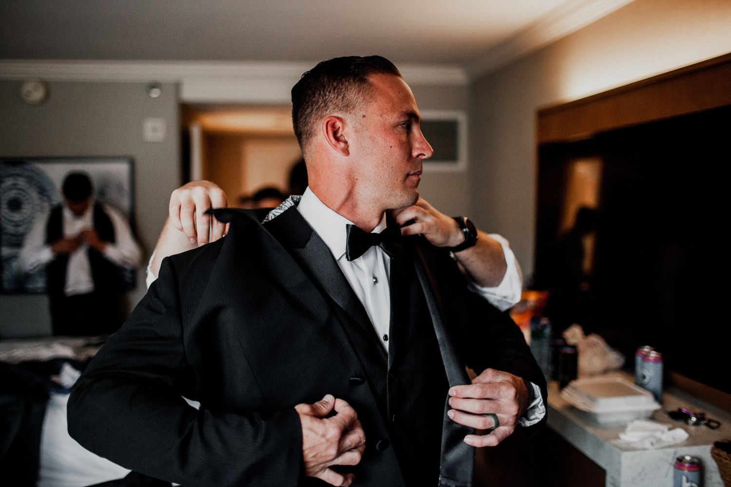groom checking if fit is okay in front of mirror