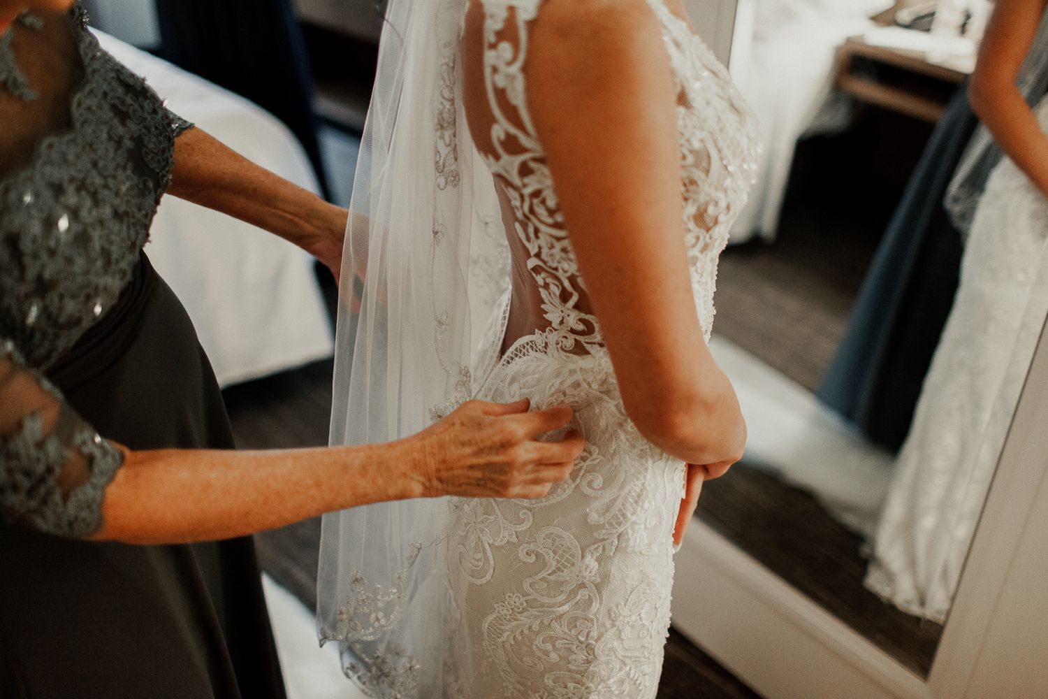 mother making last adjustments for bride's dress