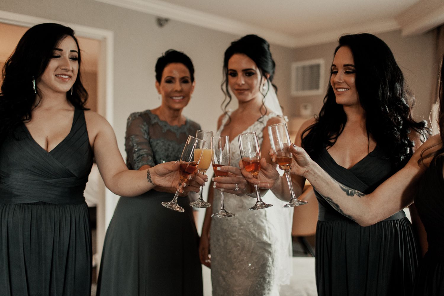 bride and bridal party cheer-sing drinks