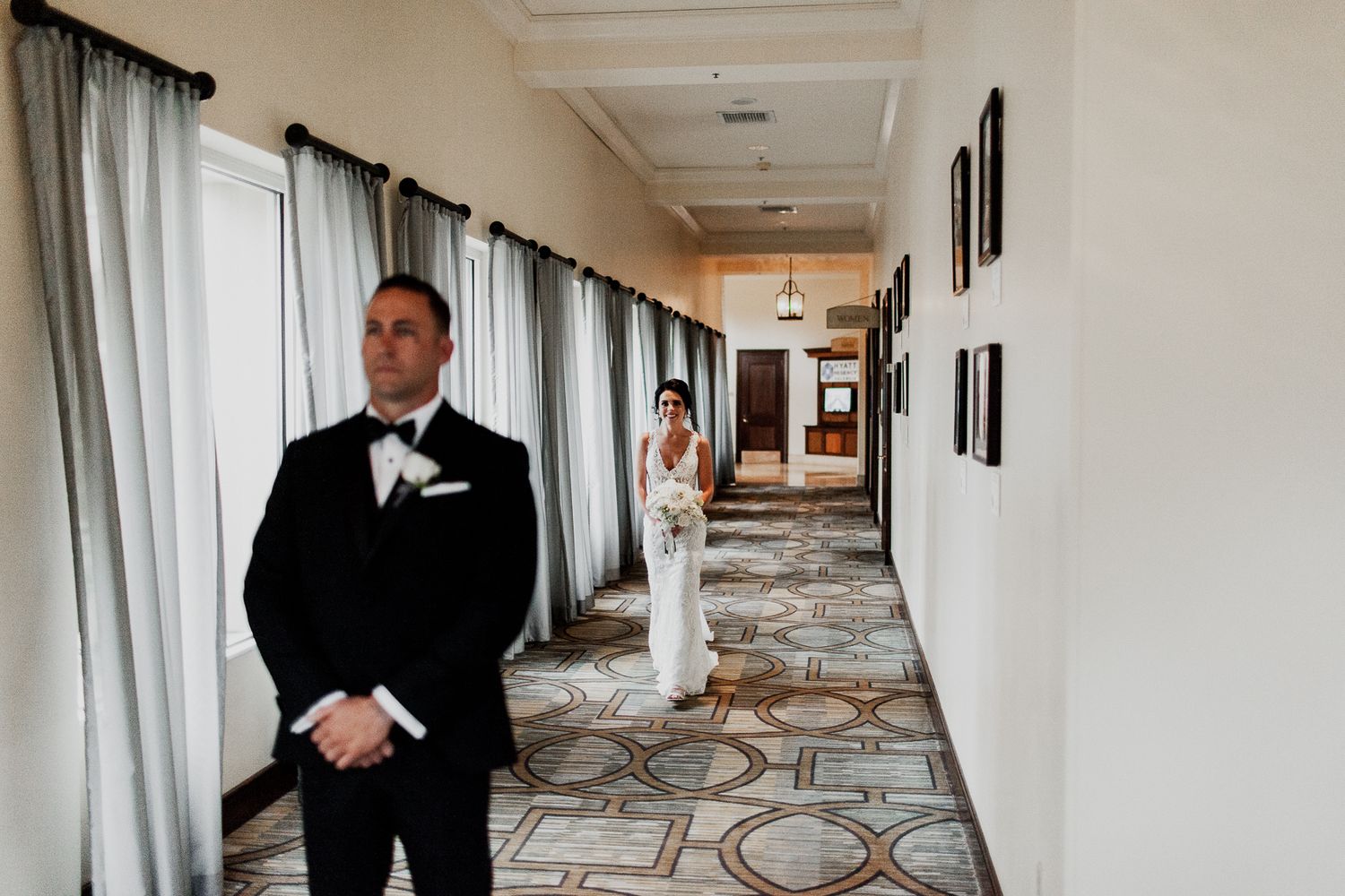 bride approaching groom for first look at hyatt regency valencia hallway