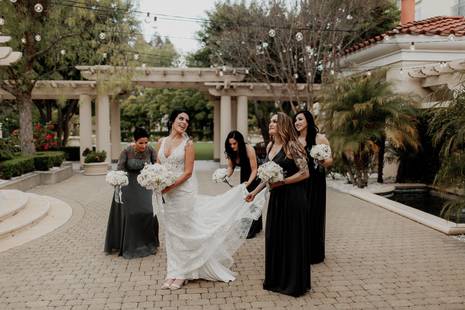 bride getting dress fluffed by bridesmaids