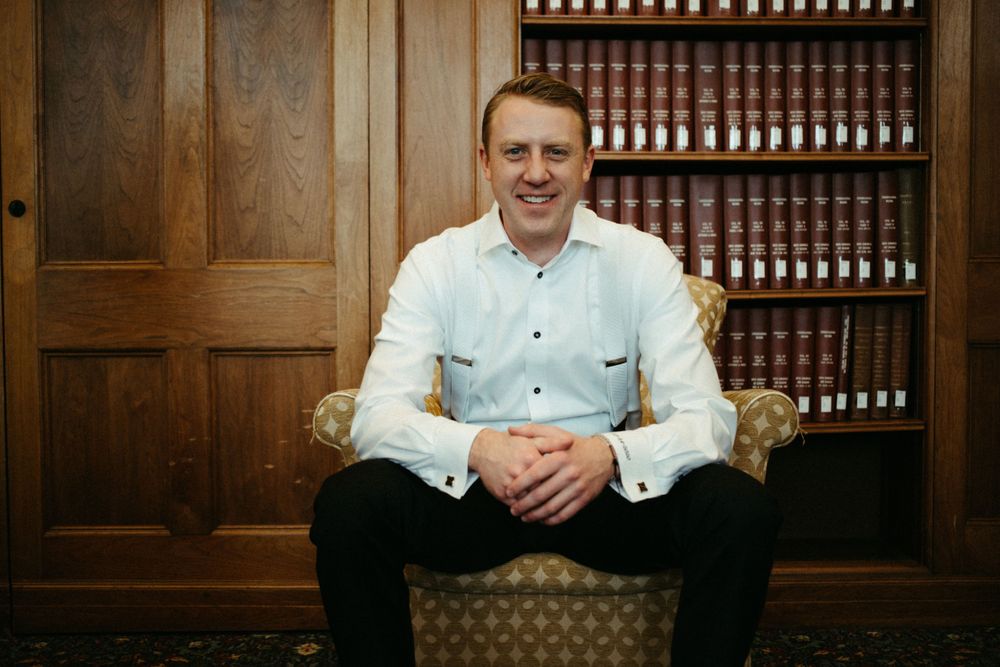 groom-sitting-wedding-cowles-library-desmoines-iowa-raelyn-ramey-photography