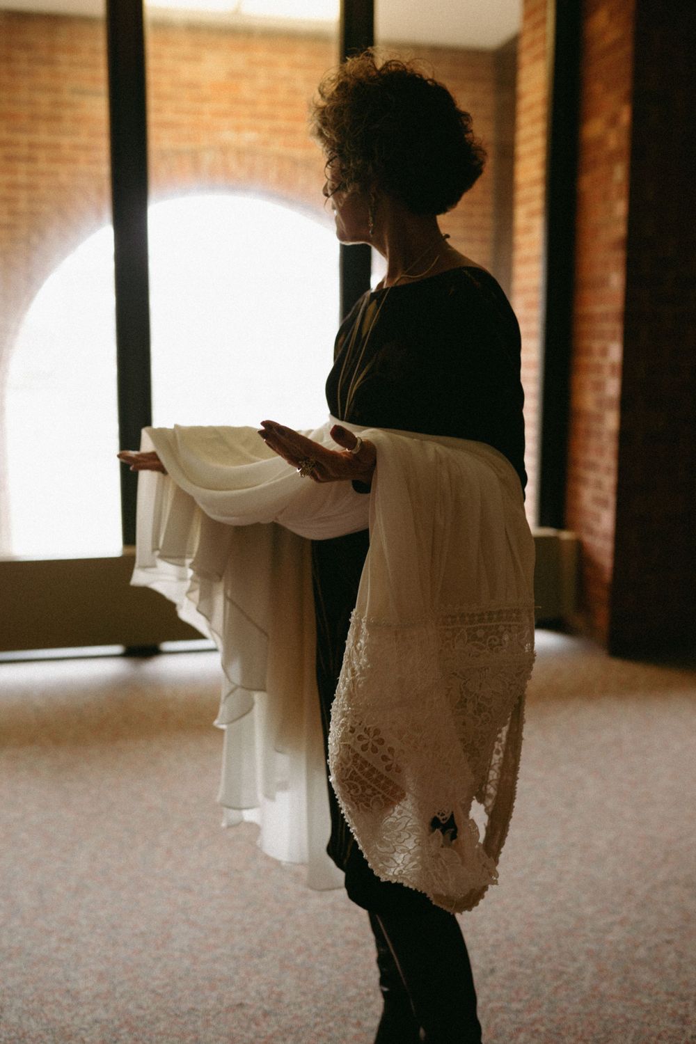 mother-of-bride-holding-dress-wedding-cowles-library-desmoines-iowa-raelyn-ramey-photography
