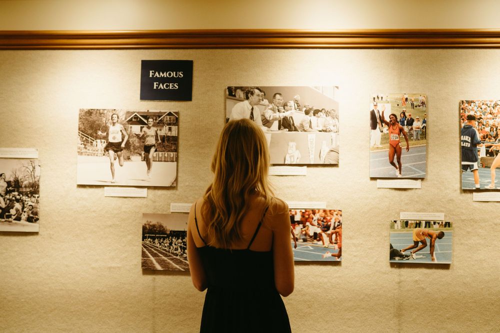 bridesmaid-standing-looking-at-art-wedding-cowles-library-desmoines-iowa-raelyn-ramey-photography