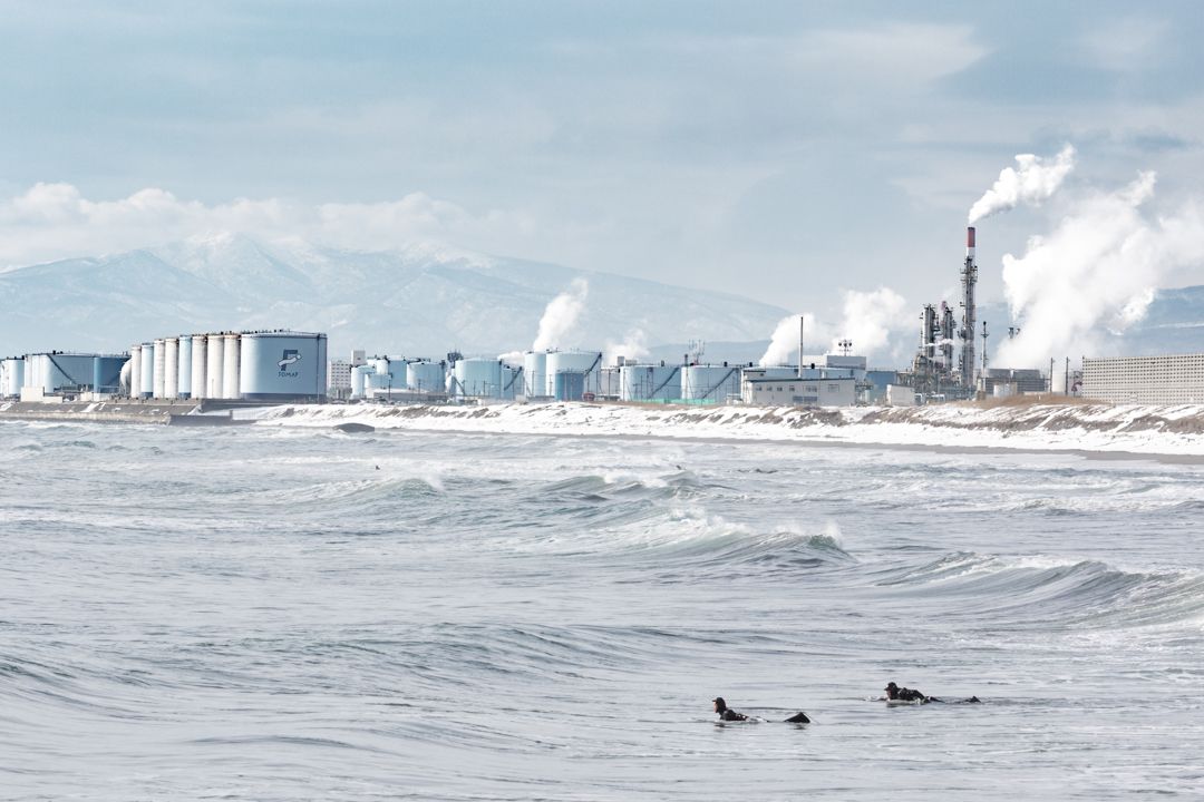 Winter coldwater surfing in industrial Japan with smoke and chimneys pollution