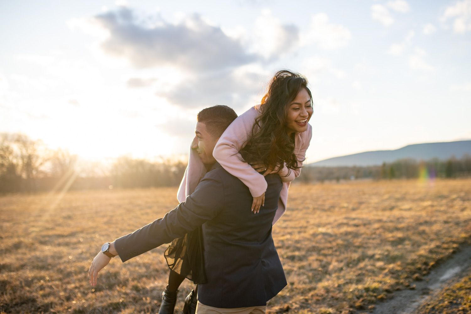 Couple laugh and play during candid adventure engagement session