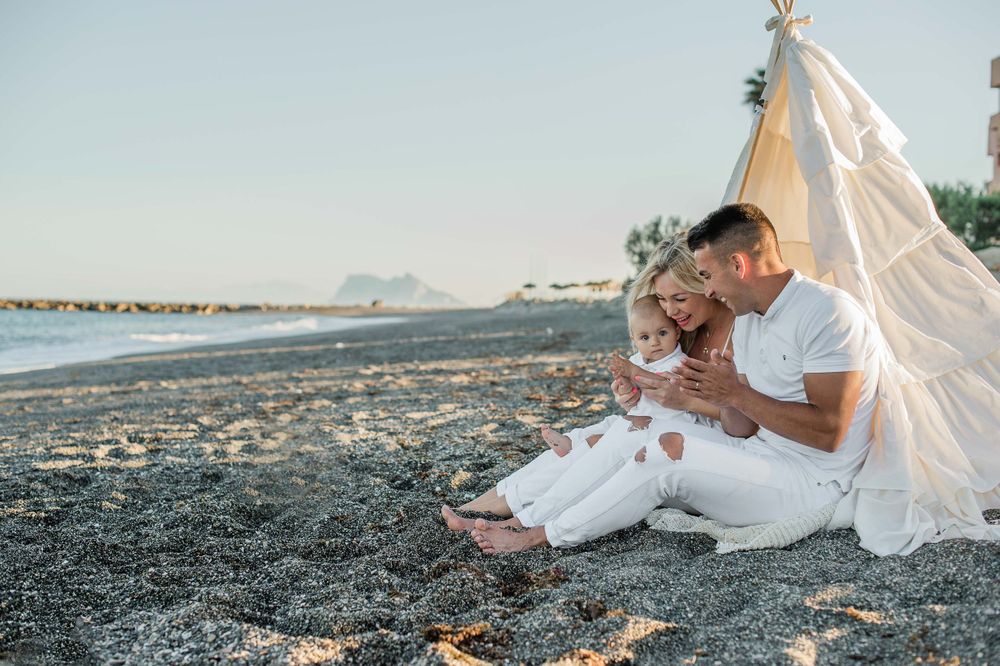 Family sitting on the beach with Gibraltar in the background