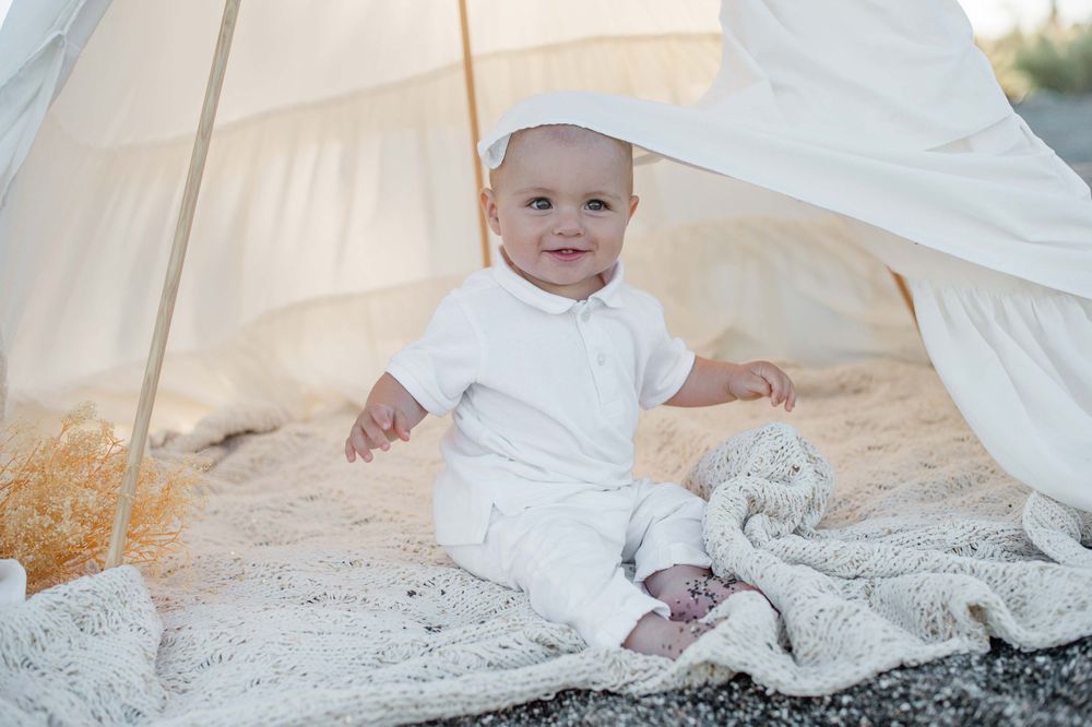 Baby boy sitting in a white tippee