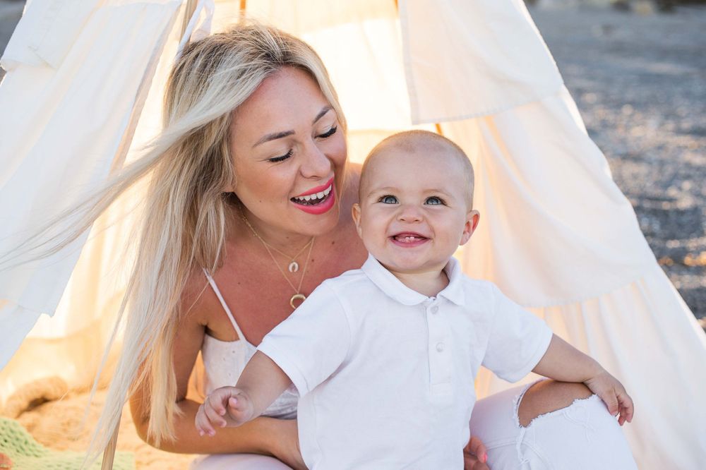 mother holding a baby smiling