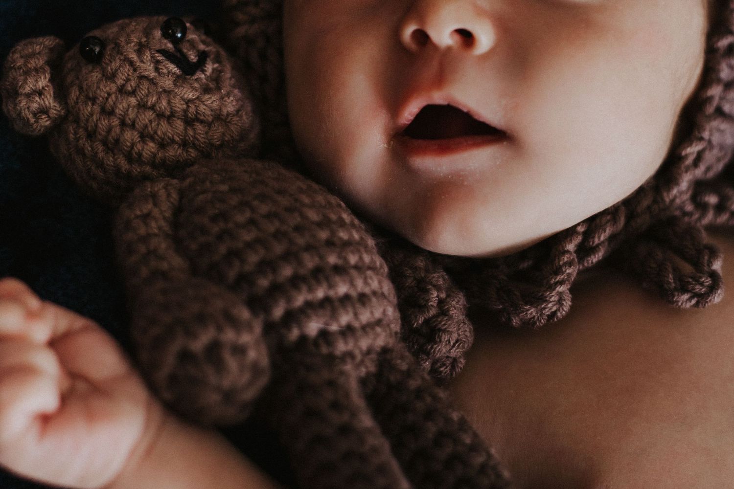 baby boy cuddles close to toy bear