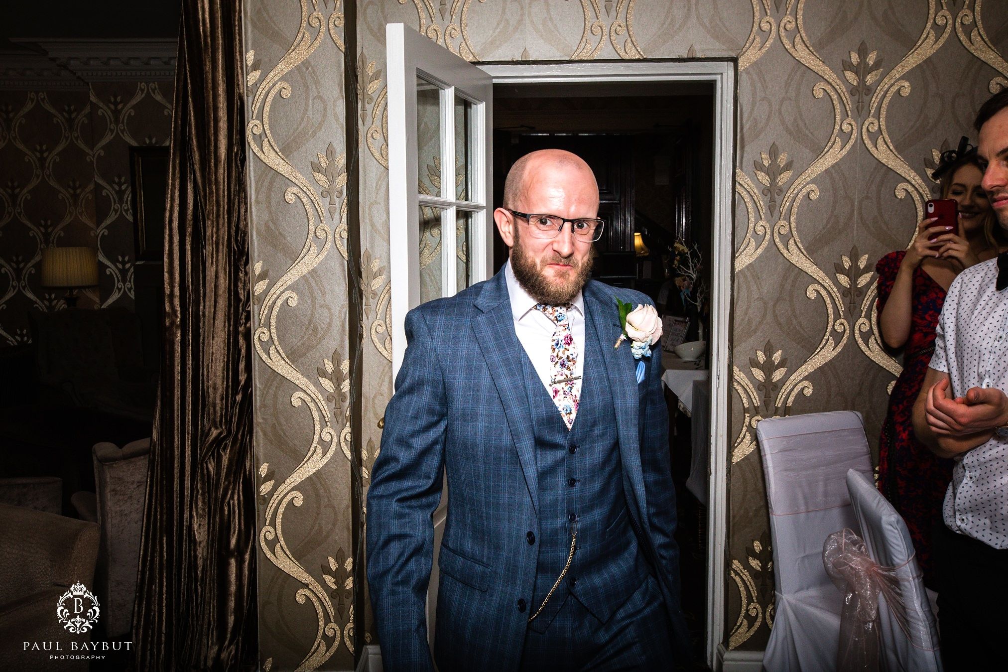 Smart suited groom enters the wedding breakfast room at his Astley Bank Hotel wedding