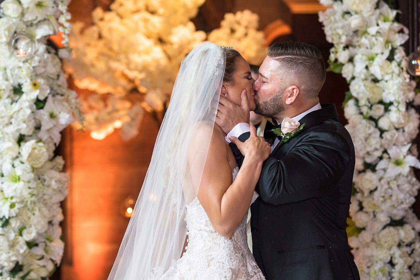 Groom at Peckforton Castle kisses his bride during the wedding ceremony in the Great Hall