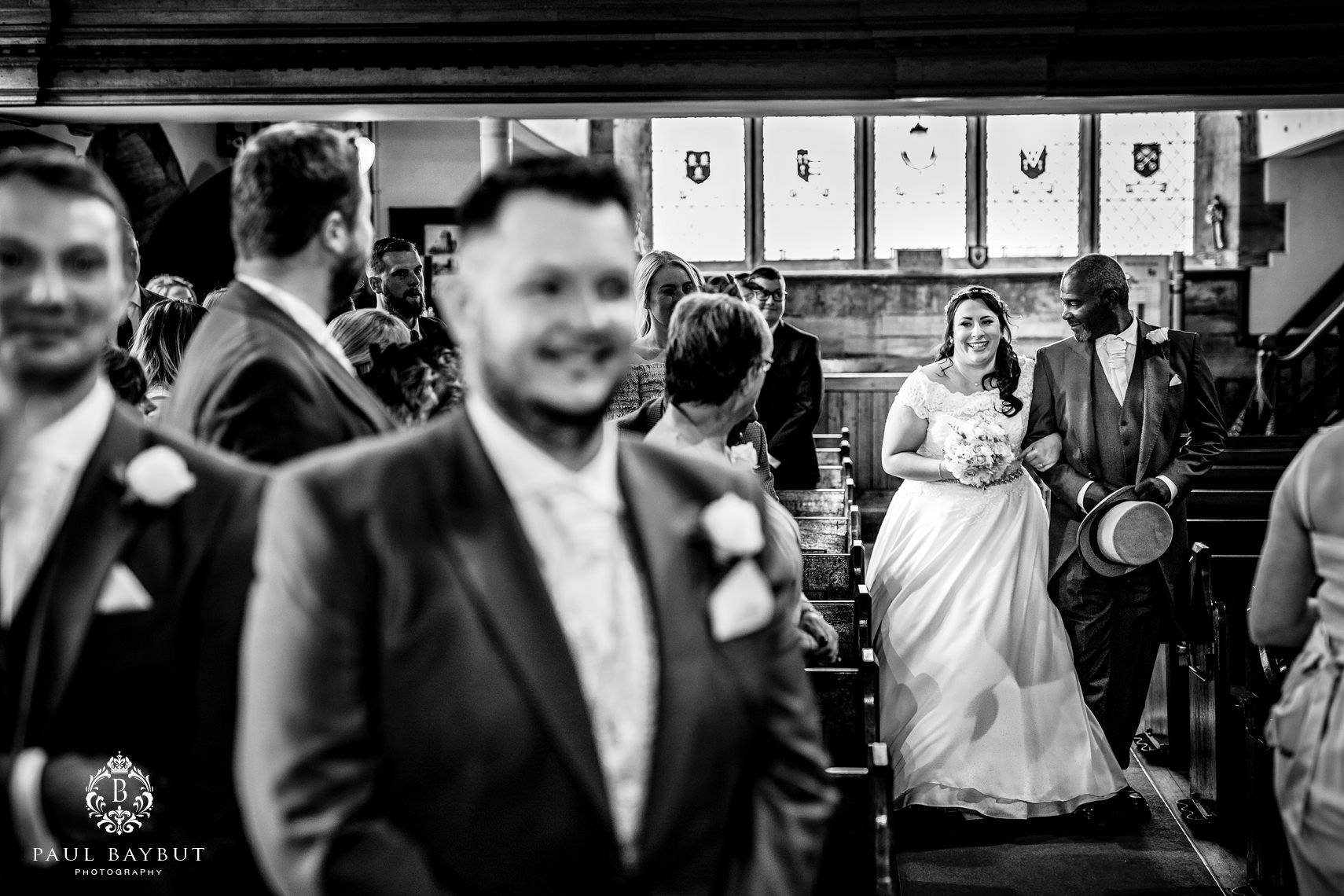 Nervous groom stands waiting in church as his bride walks down the aisle with her father on their Shrigley Hall wedding