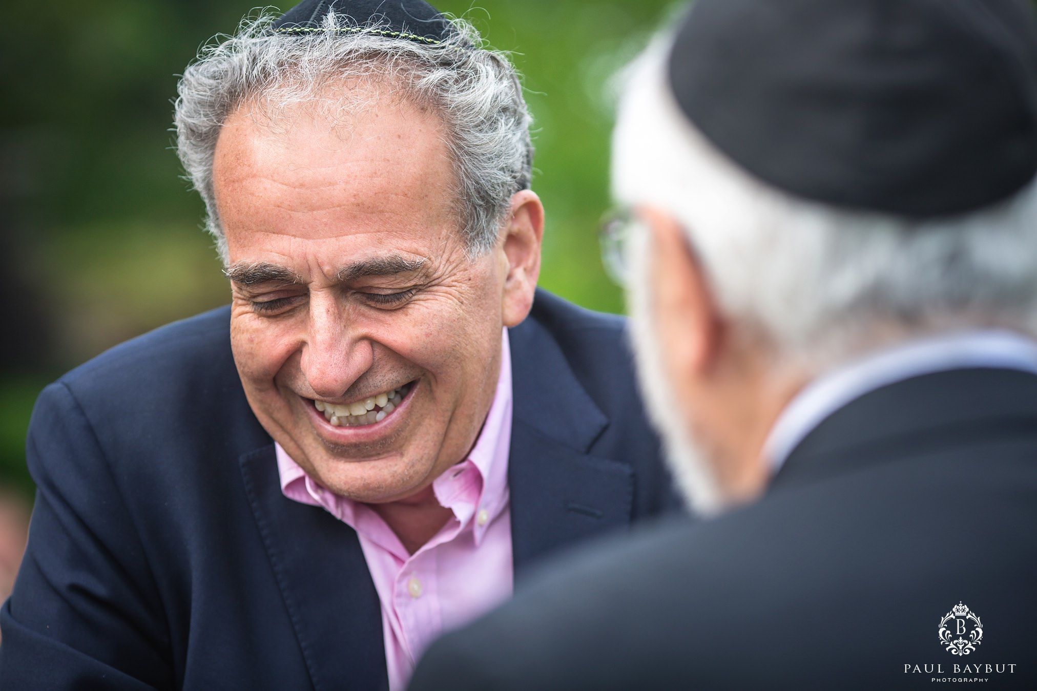 Male Jewish wedding photography guests talk and smile at a Tatton Park wedding