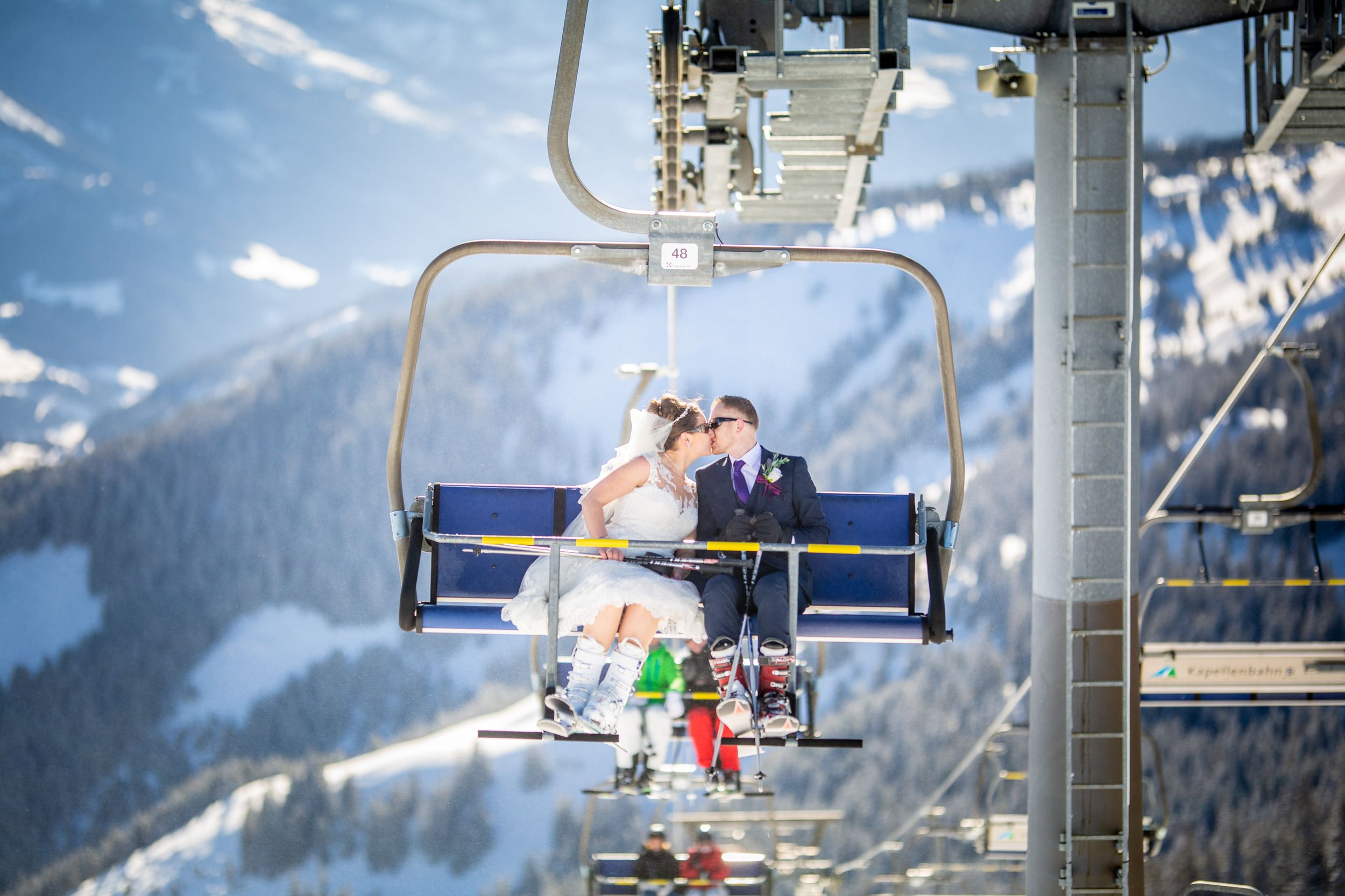 Wedding couple kisses on ski lift