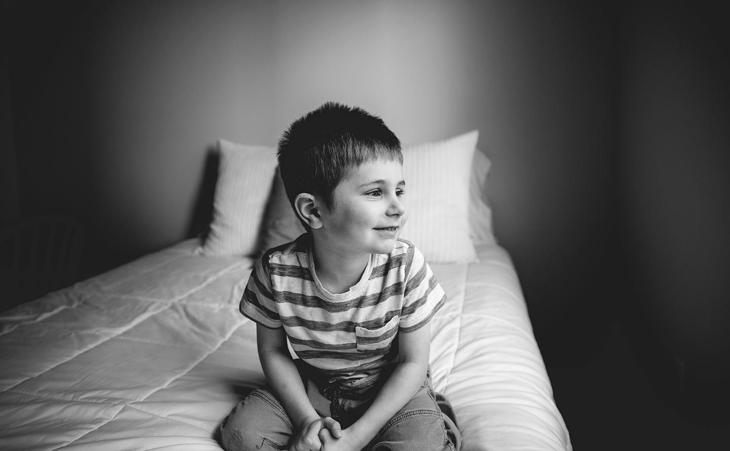 little boy smiling and looking out window