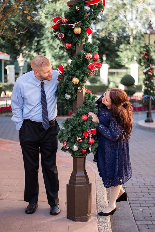A couple standing against a lamppost with Christmas decor at the UK Pavilion at Walt Disney World's Epcot in Orlando FL