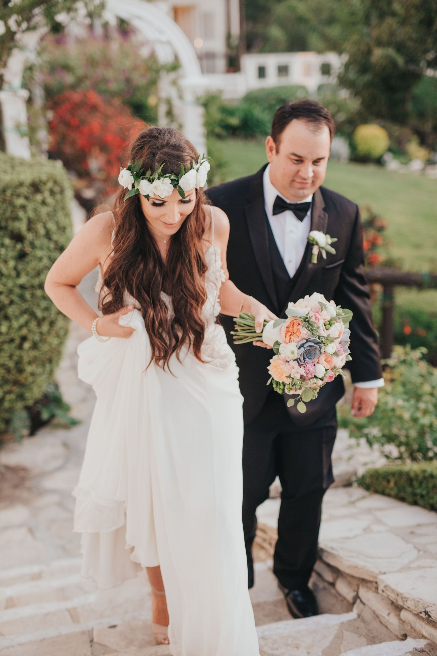 groom helping bride walk up staircase at la venta inn