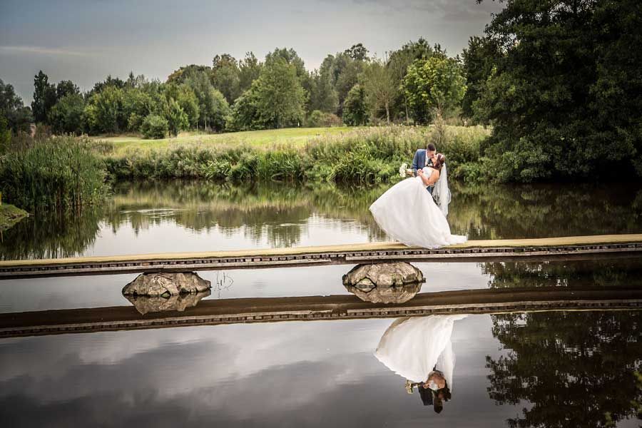 Bride and groom on boardwalk over river