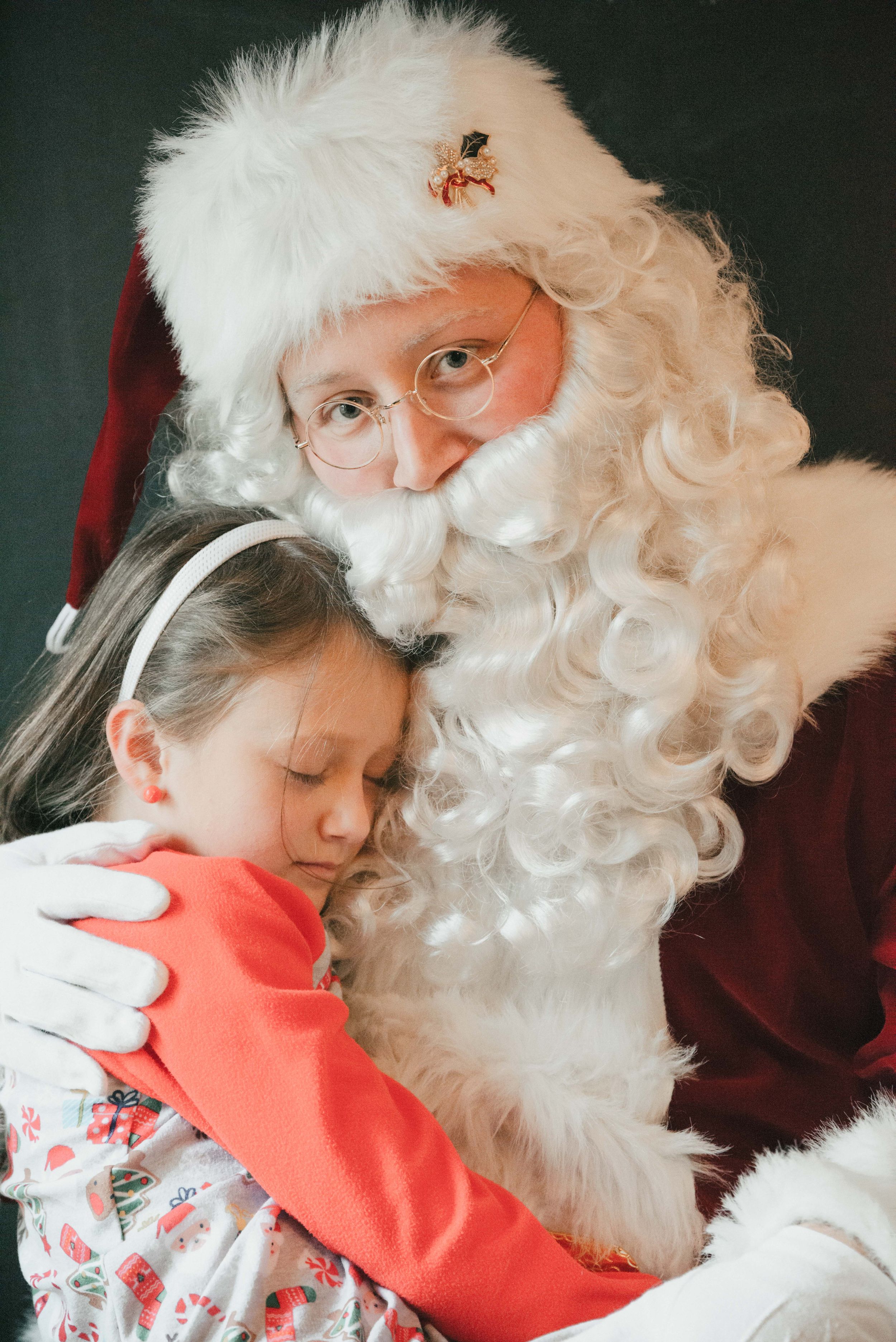 Santa with sleeping child in Christmas pajamas, Shiny Penny Studios, Cleveland