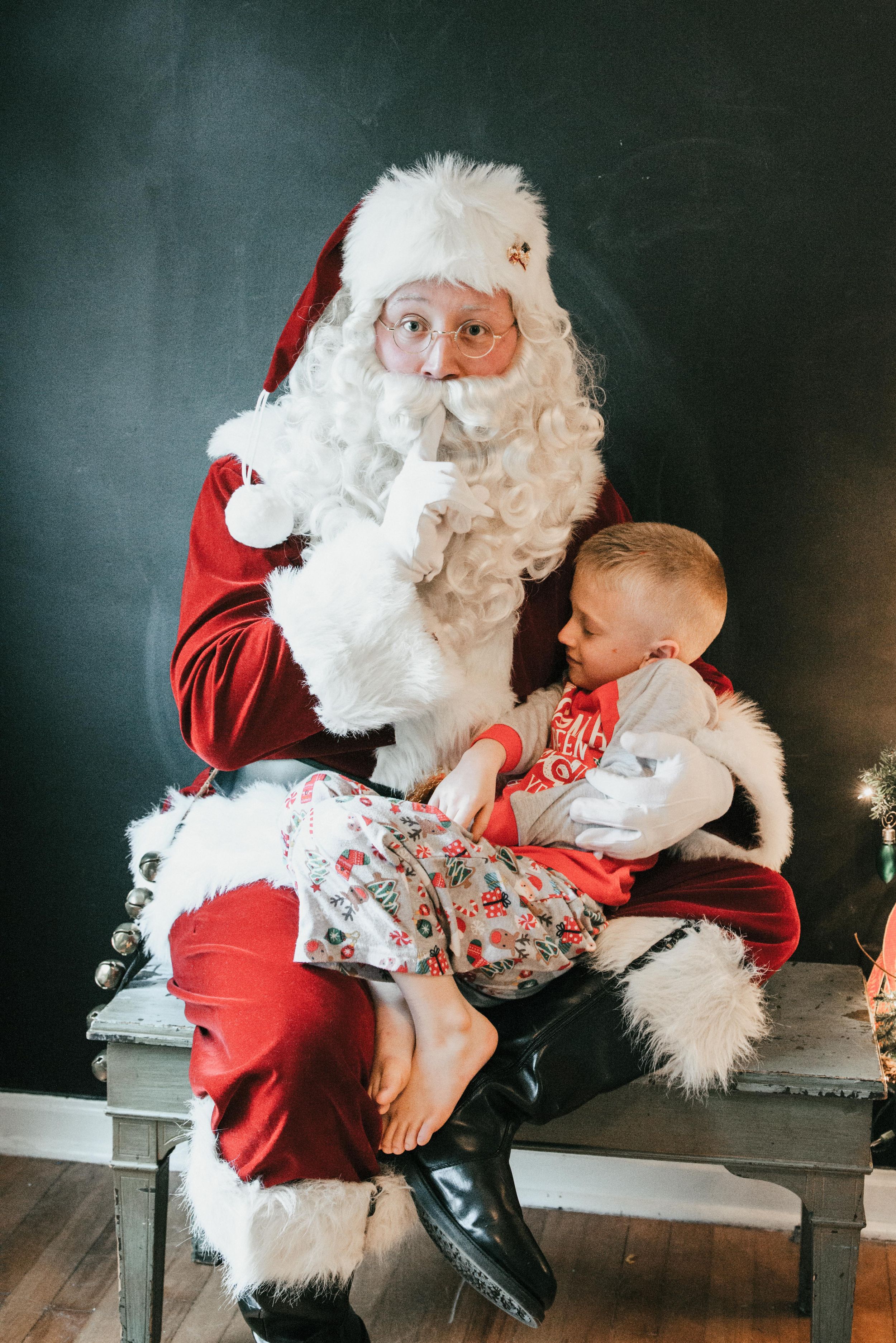 Santa with sleeping child in Christmas pajamas, Shiny Penny Studios, Cleveland