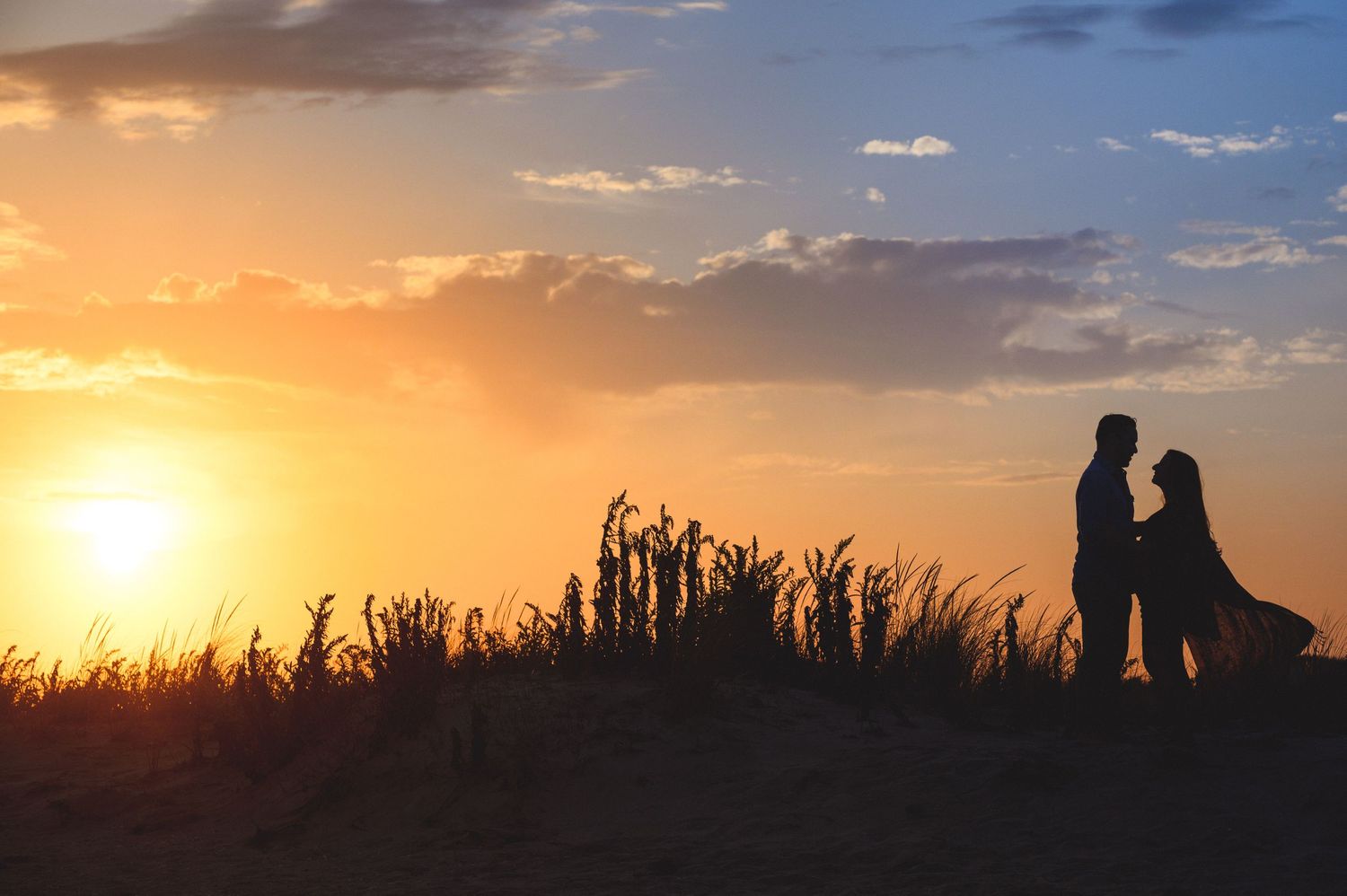 maternity couple on barnegat light beach during sunset