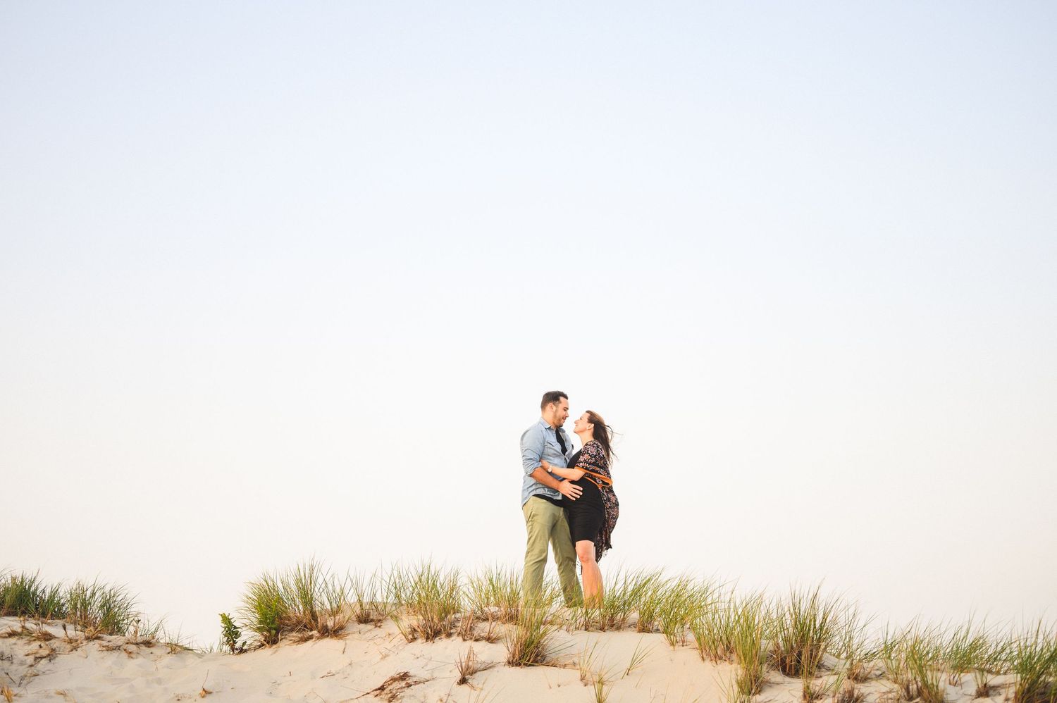 maternity couple on barnegat light beach during sunset