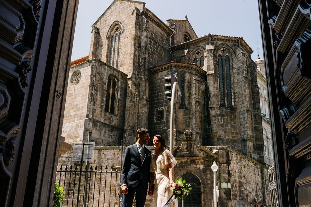 Noivos à porta da Igreja, antes de entrarem, a olhar para dentro a rir, plano de fundo Igreja São Francisco, Porto