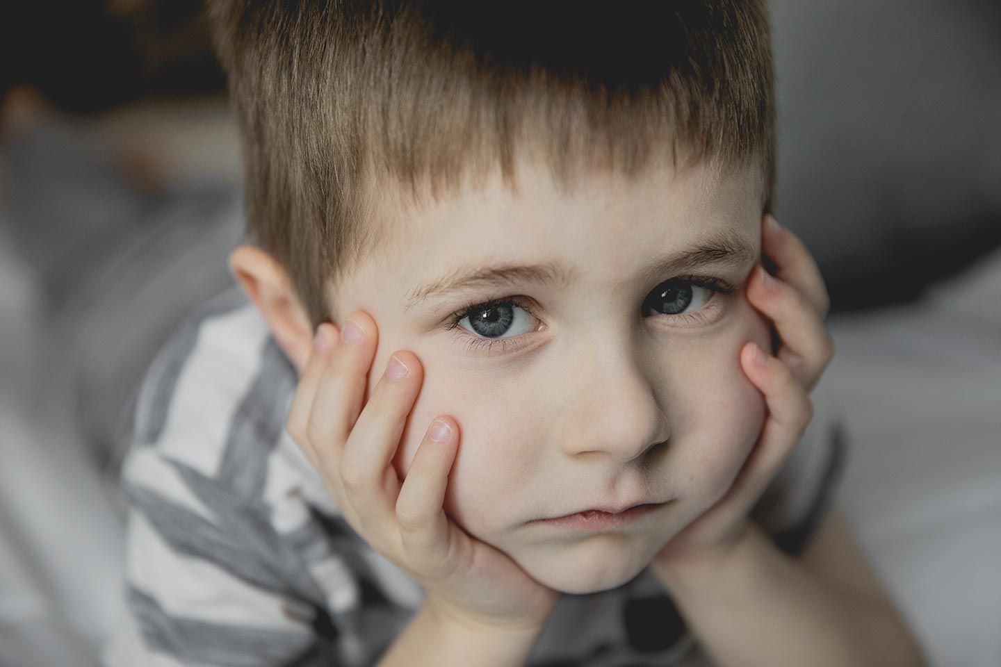 little boy with serious face on bed