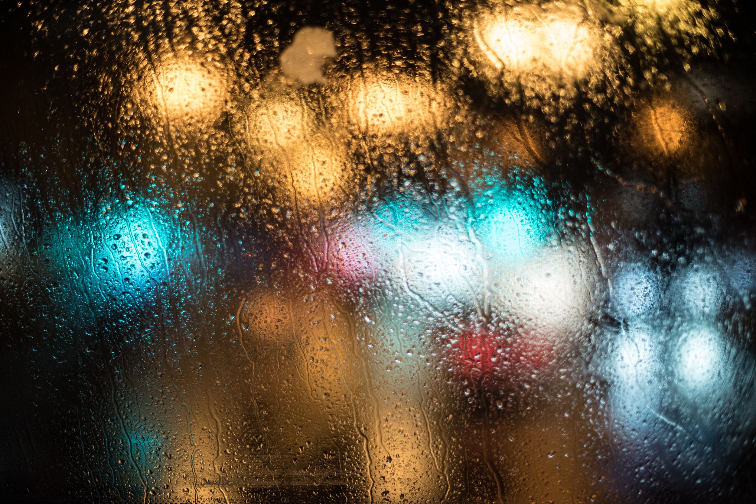 Colorful lights through a windshield on a rainy London evening