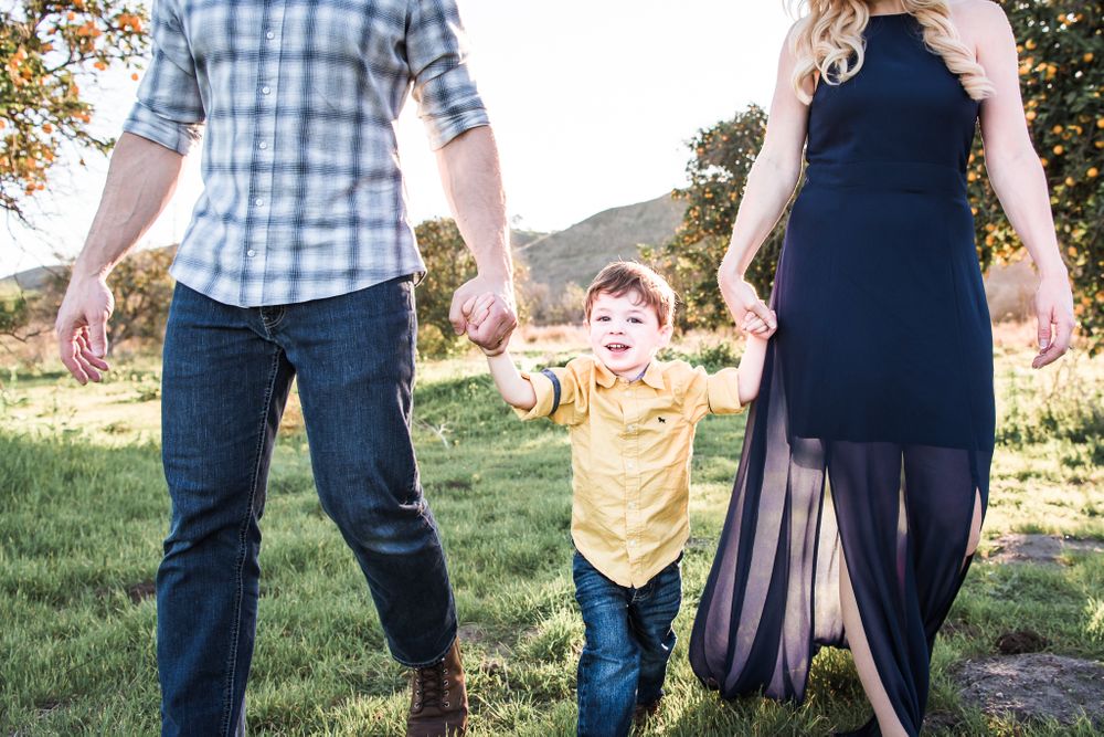 A photo of a family walking in an open field in San Juan Capistrano, CA