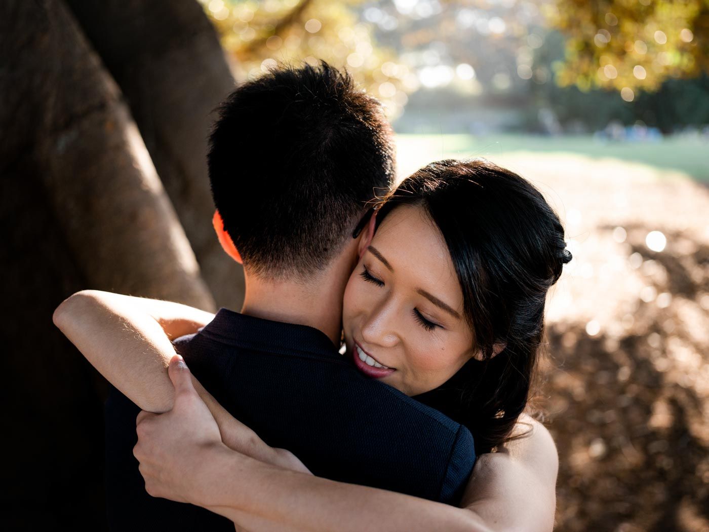 Smiling woman holding her partner with her eyes closed