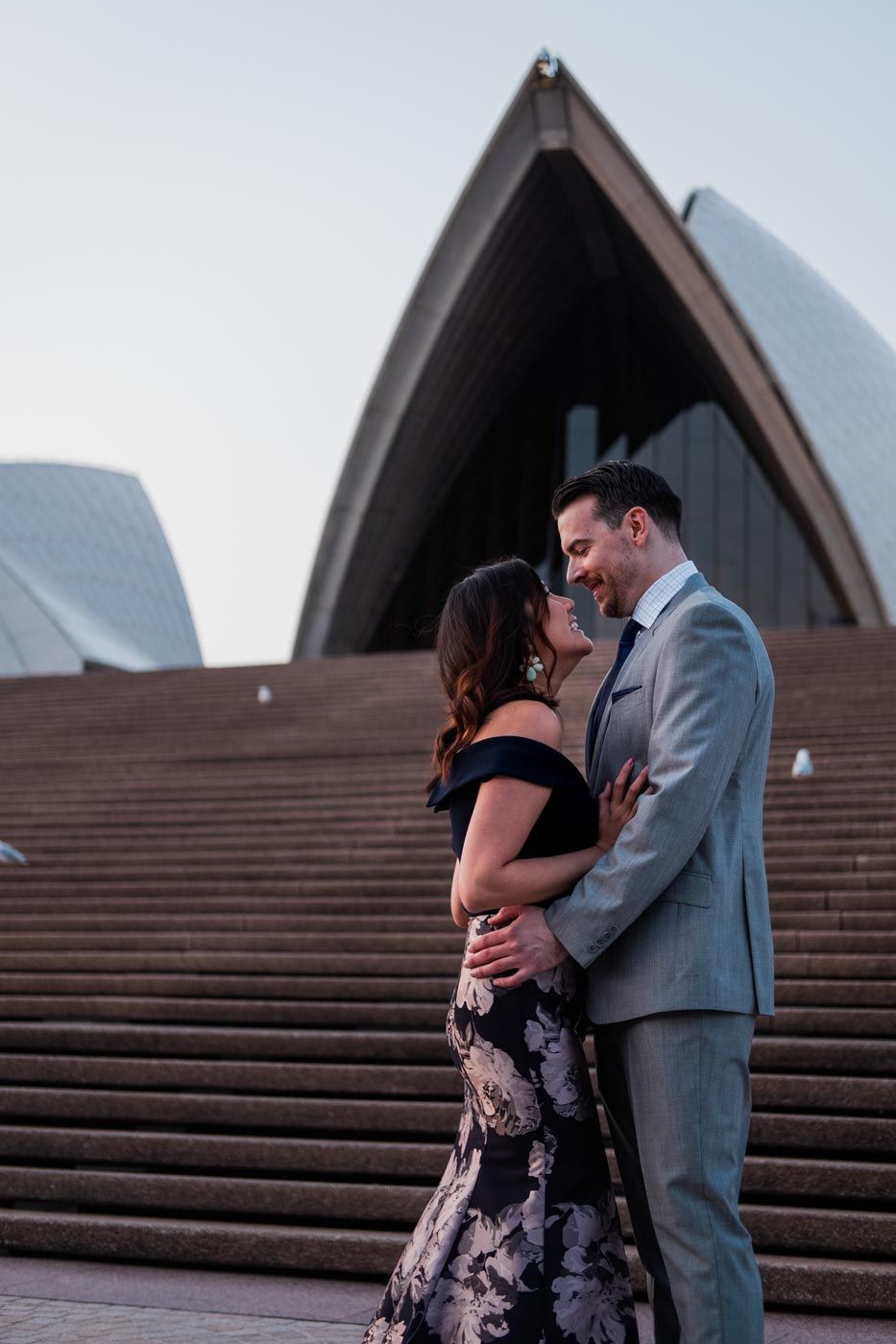 Couple sharing a laugh on the steps on the Sydney Opera House