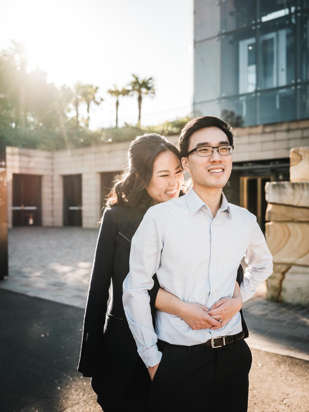 Couple hugging and laughing with the sun behind them