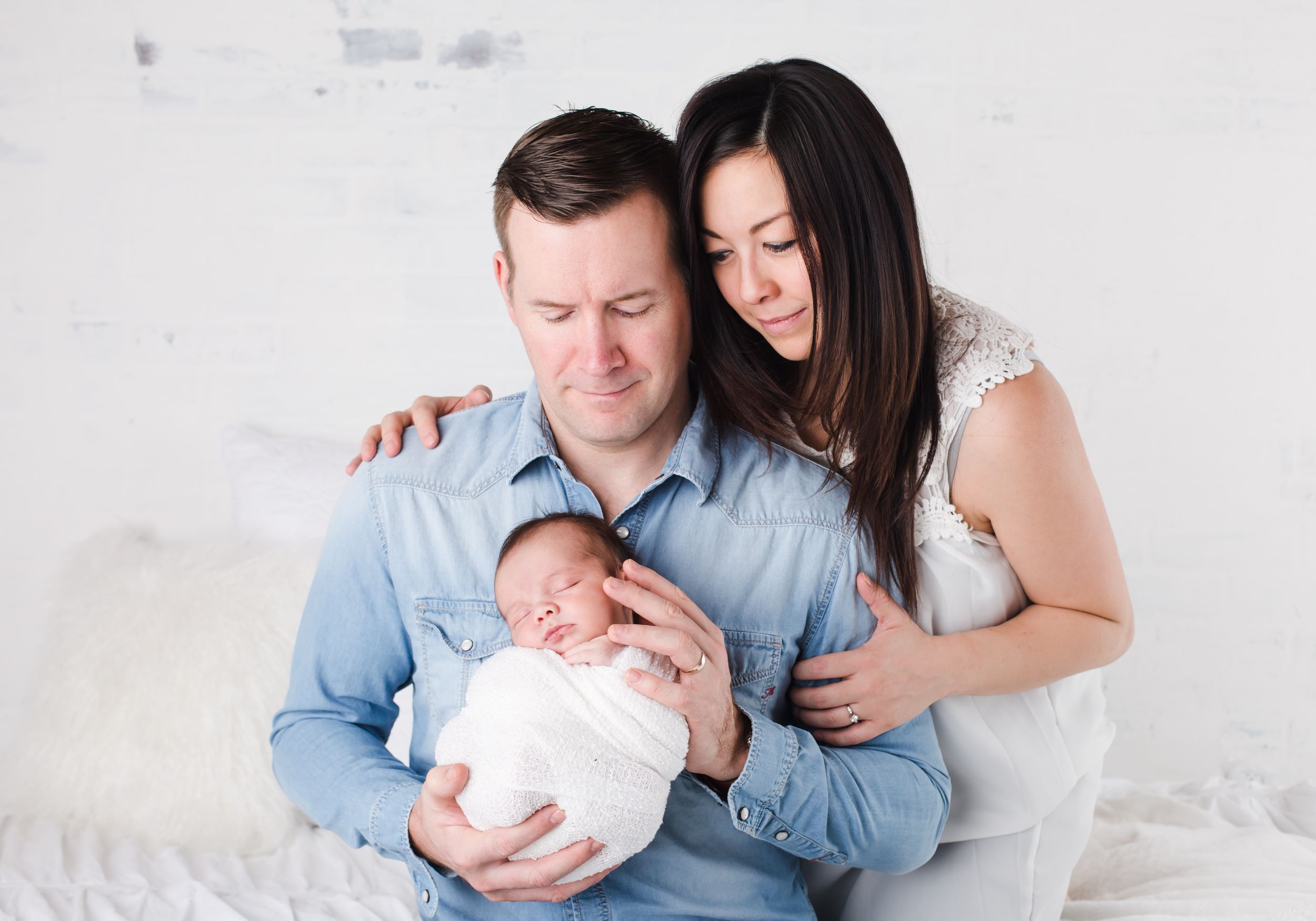 Newborn baby posed sleeping in parents arms - newborn photographer in penticton bc