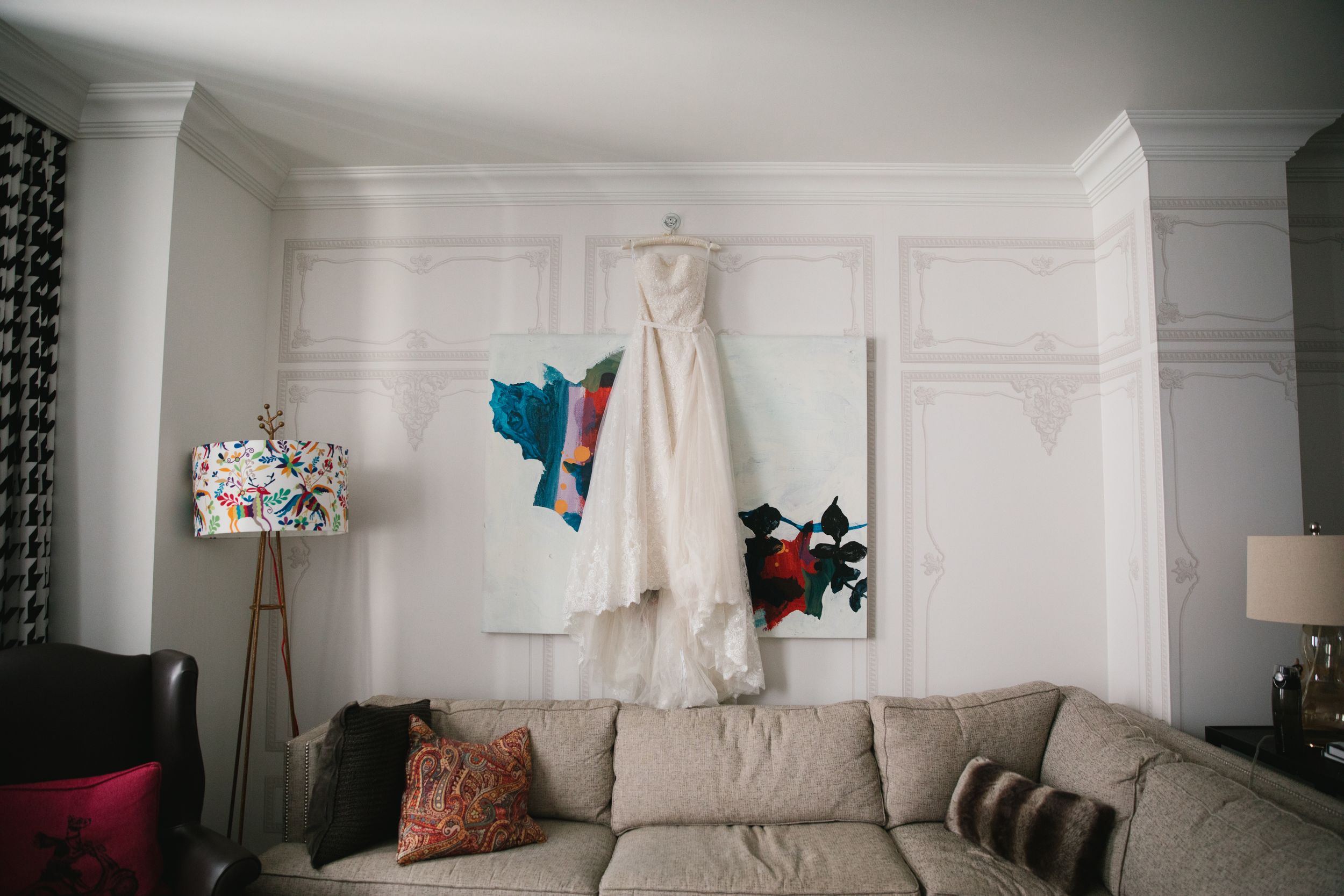 white wedding dress hanging in hotel room above sofa monaco pittsburgh