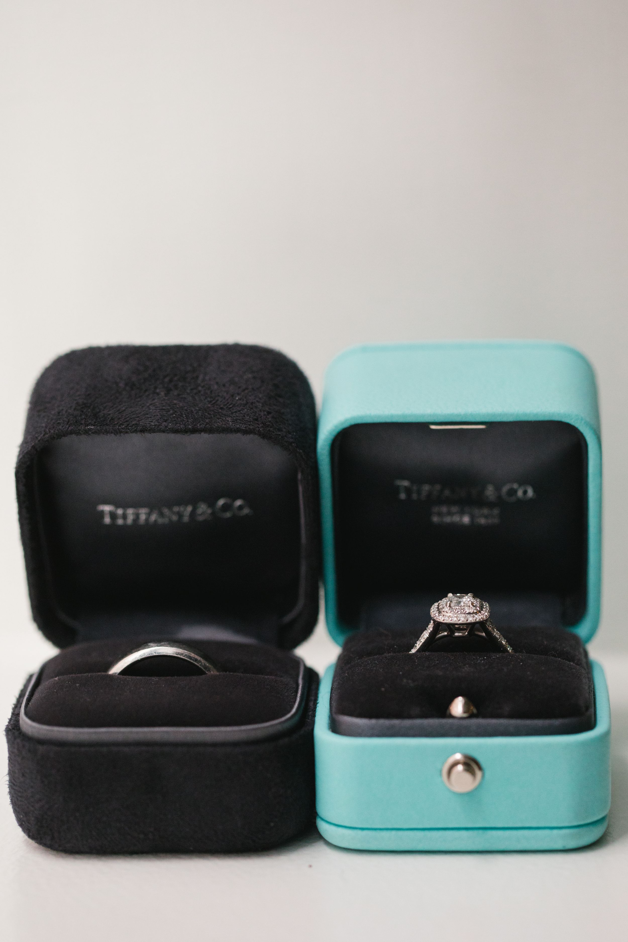 close up of wedding rings in ring boxes, one black and one tiffany's blue
